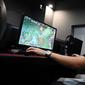 Seorang pria bermain game komputer di sebuah kafe internet di Beijing, China, Jumat (10/9/2021). Pejabat China memanggil perusahaan game, termasuk dua yang terbesar yaitu Tencent dan NetEase, untuk membahas pembatasan lebih lanjut pada industri game online. (GREG BAKER/AFP)