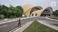 Aktivitas pekerja kebersihan dekat gedung teater berbentuk keong mas Taman Mini Indonesia Indah (TMII), Jakarta Timur, Senin (7/11/2022). Revitalisasi yang dilakukan meliputi bangunan luar, lanskap, desain interior, serta penambahan koleksi museum dan fasilitas pendukung lainnya untuk menambah daya tarik pengunjung. (merdeka.com/Iqbal S Nugroho)