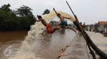 Sejumlah anak bermain di bantaran kali Ciliwung, Kampung Pulo, Jakarta Timur, Sabtu (12/3). Warga memanfaatkan lahan di aliran sungai untuk tempat bermain karena minimnya lahan kosong di sekitar wilayah itu.(Liputan6.com/Gempur M Surya)