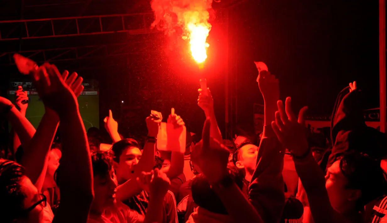 Sejumlah supporter klub Arsenal menyalakan flare saat mengikuti acara Nonton Bola Seru Arsenal vs Chelsea di Andik Futsal, Depok, Jawa Barat, Minggu (26/4/2015). Kedua tim bermain imbang 0-0. (Liputan6.com/Helmi Fithriansyah)