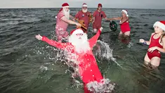 Sinterklas dari penjuru dunia menikmati bermain air laut Klampenborg di luar Kopenhagen, Denmark, Selasa (25/7). Lima bulan menjelang natal, ratusan Sinterklas berkumpul dalam Kongres Dunia Sinterklas yang ke 60. (Tobias Nicolai / Ritzau Foto via AP)