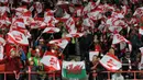 Fans cilik asal Wales membentangkan bendera kebangsaannya di tengah-tengah kerumunan tribun fans Austria. (Bola.com/Reza Khomaini)