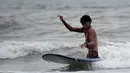 Imigran Venezuela, Alfonso Mendoza alias Alca bermain surfing di Puerto, Kolombia, 27 September 2018. Lahir tanpa kaki dan ditinggalkan oleh orangtuanya, membuat Alca sempat berpikir untuk bunuh diri. (Raul ARBOLEDA/AFP)