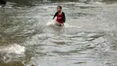 Seorang anak asyik bermain banjir yang merendam kawasan Benhil RT 03 RW 05, Jakarta Pusat, Selasa (21/1). Hujan deras yang mengguyur sejak Selasa dinihari mengakibatkan kawasan tersebut mengalami banjir. (Liputan6.com/Johan Tallo)