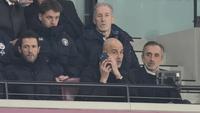 Pelatih Manchester City, Pep Guardiola, memberikan arahan melalui telpon dari tribun penonton saat anak asuhnya bermain imbang 1-1 melawan West Ham United pada pekan ke-30 Premier League 2025/2026 di London Stadium pada Minggu (15/3/2026). (AP Photo/Dave Shopland)