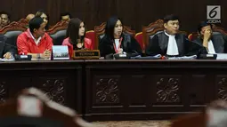 Kuasa hukum pemohon (tengah) membacakan nota saat sidang perdana permohonan uji materi UU Nomor 7 Tahun 2017 tentang Penyelenggaraan Pemilu di Gedung MK, Jakarta, Selasa (5/9). Ada tiga pasal yang diuji materikan. (Liputan6.com/Helmi Fithriansyah)
