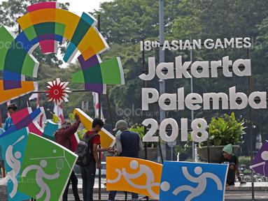 Pekerja sedang merampungkan pengerjaan logo Asian Games 2018 di Bundaran HI, Jakarta, (17/8/2017), Asian Games mengambil tema Energy Of Asia dan akan dibuka oleh Presiden Republik Indonesia Joko Widodo. (Bola.com/Nicklas Hanoatubun)