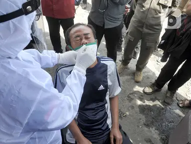 Petugas kesehatan mengambil sampel usap saat rapid tes antigen di kawasan Pasar Cisarua, Bogor, Jumat (12/2/2021). Tes cepat antigen oleh petugas gabungan Satgas Covid-19 itu dilakukan secara acak untuk antisipasi penyebaran COVID-19 dari wisatawan di kawasan Puncak Bogor. (merdeka.com/Arie Basuki)