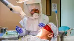 Dr. Maureen P. Ines-Manzano, seorang dokter gigi, memeriksa pasiennya di dalam kliniknya di Manila, Filipina, pada 19 Oktober 2020. Pasien Dr. Manzano menjulukinya "dokter gigi astronaut" karena mengenakan setelan PAPR untuk melindungi pasien dan dirinya dari COVID-19. (Xinhua/Rouelle Umali)