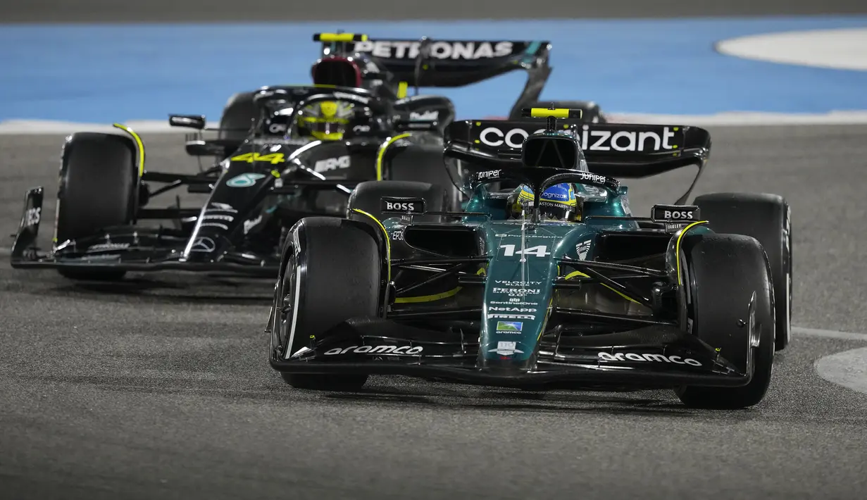 Pebalap Aston Martin, Fernando Alonso (kanan) memacu mobilnya di depan pebalap Mercedes-AMG, Lewis Hamilton saat Formula 1 GP Bahrain 2023 yang berlangsung di Sirkuit Internasional Bahrin, Sakhir, Minggu (05/03/2023) WIB. (AP Photo/Frank Augstein)