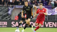 Pemain Venezia, Jay Idzes (kiri) menggiring bola melewati pemain Fiorentina dalam laga lanjutan Liga Italia 2024/2025 di Stadio Pier Luigi Penzo, Venezia, Italia, Senin (12/05/2025) waktu setempat. (AP Photo/LaPresse/Paola Garbuio)