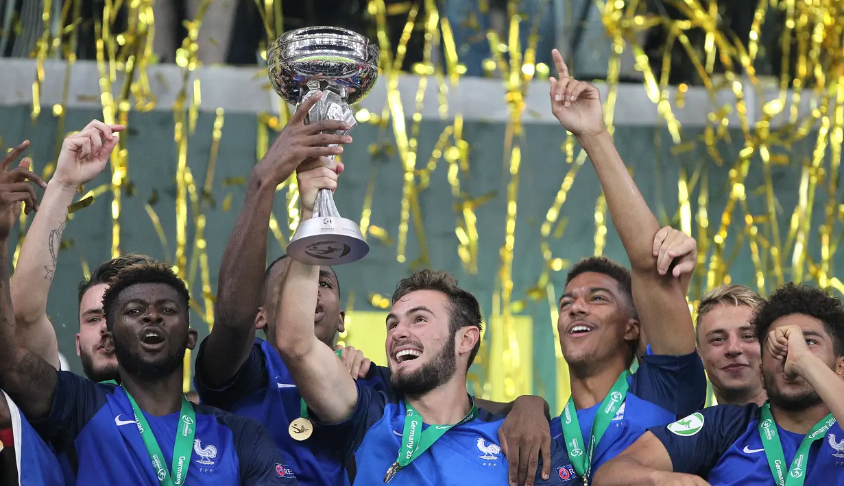 Gelandang Prancis Lucas Tousart memegang trofi saat merayakan dengan rekan setim usai memenangkan Piala Eropa 2016 U-19, Jerman, Minggu (24/7). Di final Prancis menang 4-0 dari Italia.(AFP PHOTO/Daniel Roland) 