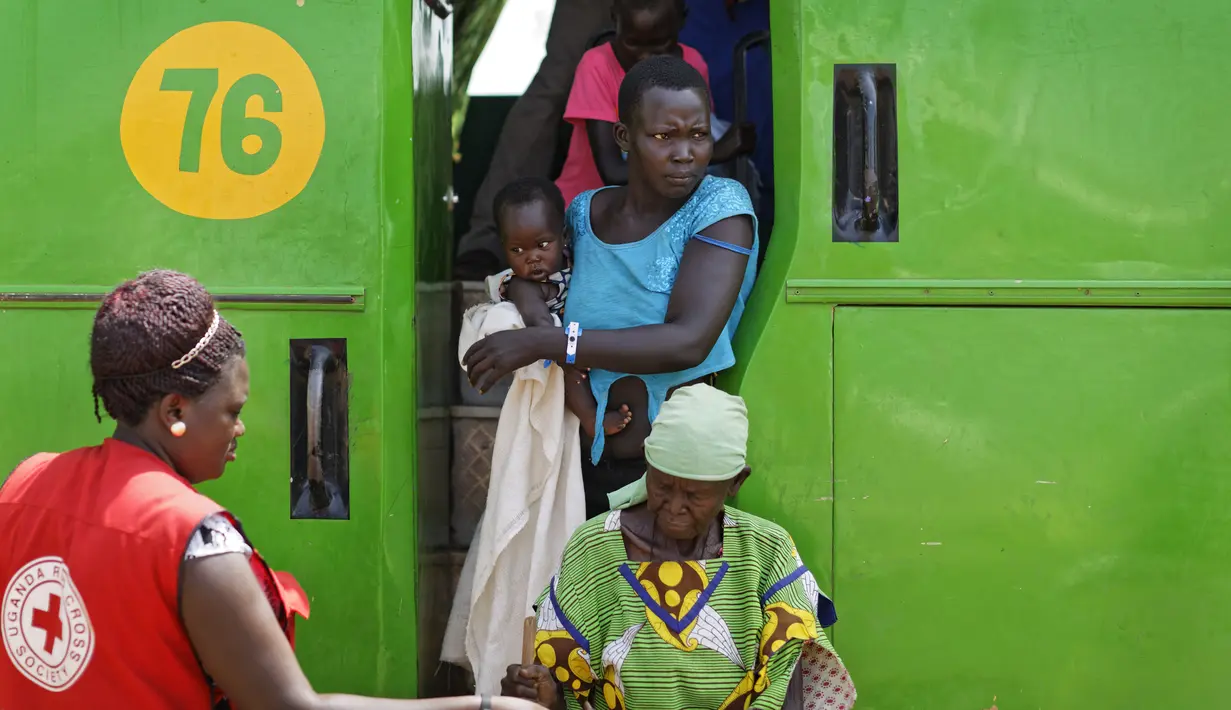 Seorang pengungsi menggendong anaknya saat tiba di Bidi Bidi, Uganda, Selasa (6/6). Bidi Bidi adalah pemukiman pengungsi terbesar di dunia yang menampung pengungsi Sudan Selatan. (AP Photo / Ben Curtis)