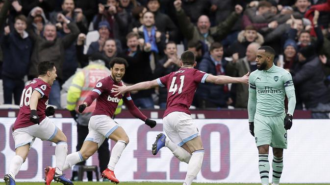 Para pemain West Ham United merayakan gol yang dicetak oleh Declan Rice usai membobol gawang Arsenal pada laga Premier League di Stadion London, Sabtu (12/1). West Ham United menang 1-0 atas Arsenal. (AP/Tim Ireland)