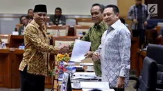 Ketua KPK Agus Rahardjo menyerahkan daftar barang sitaan kepada pimpinan rapat dengar pendapat (RDP) Komisi III, Benny K. Harman di gedung DPR, Senayan, Jakarta, Selasa (26/9). Rapat tersebut membahas evaluasi kinerja KPK. (Liputan6.com/Johan Tallo)
