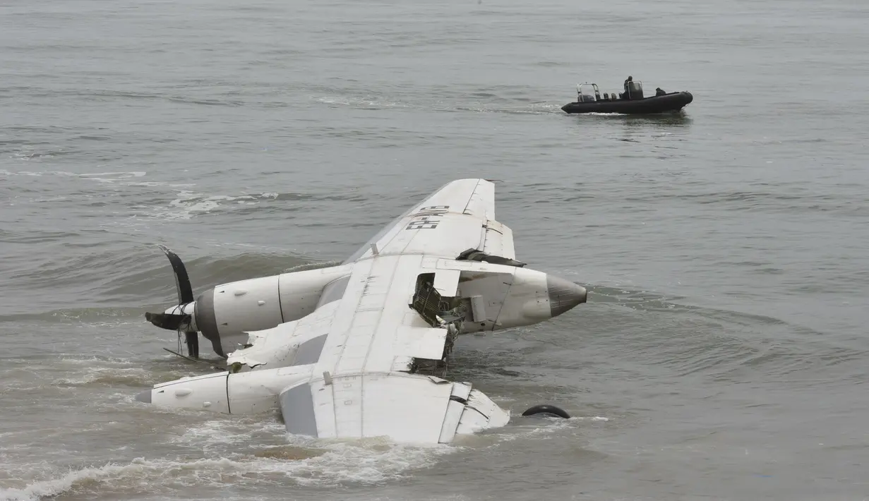 Pasukan keamanan berlayar di lepas pantai Port-Bouet,di dekat lokasi jatuhnya pesawat kargo Antonov yang menewaskan 4 orang warga Moldovan di Abidjan (14/10). Pesawat tersebut jatuh akibat dihantam ombak Pantai Gading. (AFP PHOTO / Sia KAMBOU)