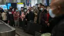 Pelancong yang memakai masker menunggu barang bawaan mereka di area kedatangan internasional di Bandara Internasional Ibukota Beijing di Beijing, Senin (9/1/2023). Pelancong internasional pertama tiba di China tanpa karantina wajib yang telah diberlakukan pada awal penerbangan. Pandemi tiga tahun lalu setelah pembatasan dicabut mulai hari Minggu. (AP/Mark Schiefelbein)
