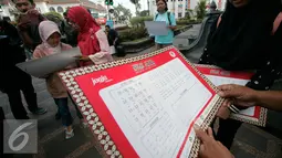 Tabel aksara Jawa yang dibagikan kepada warga di Titik Nol km saat peringatan Hari Aksara Internasional ke-50, Yogyakarta, Kamis (8/9). (Liputan6.com/ Boy Harjanto)