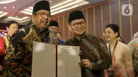Pasangan Gubernur dan Wakil Gubernur Provinsi Daerah Khusus Jakarta terpilih, Pramono Anung dan Rano Karno menunjukkan surat keputusan Komisi Pemilihan Umum Daerah (KPUD) Jakarta usai menghadiri rapat pleno di Hotel Pullman Central Park, Jakarta, Kamis (9/1/2024). (Liputan6.com/Herman Zakharia)