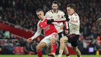 Pemain Arsenal, Leandro Trossard (kiri), dan pemain Liverpool, Florian Wirtz, saling berebut bola dalam pertandingan Liga Inggris di Emirates, Jumat (9/1/2026). (AP Photo/Ian Walton)