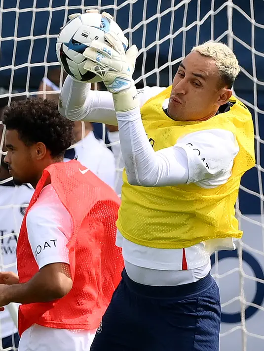 Pemain Paris Saint-Germain (PSG) Keylor Navas (kanan) melompat ke arah bola selama sesi latihan jelang melawan Monaco, di Saint-Germain-en-Laye, barat Paris pada 26 Agustus 2022. Laga PSG vs AS Monaco di lanjutan Ligue 1 Prancis akan berlangsung pada 29 Agustus 2022 dinihari WIB. (FRANCK FIFE / AFP)