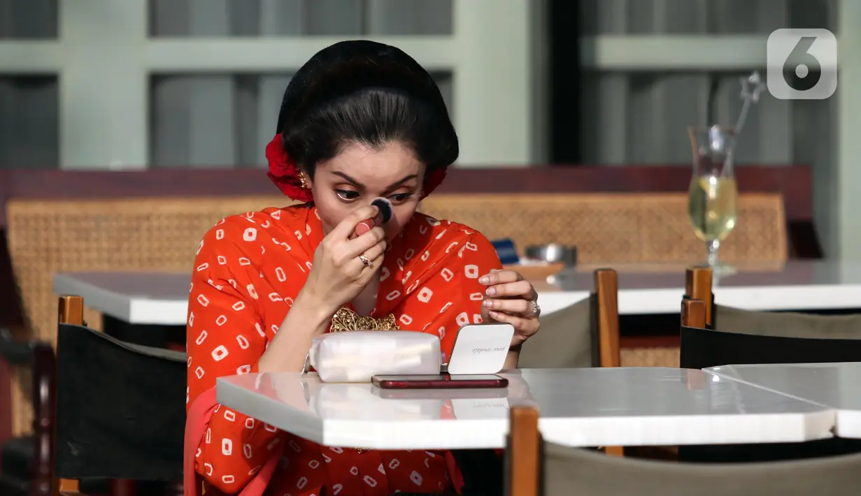 Salah satu anggota komunitas kebaya berdandan sesaat sebelum melakukan peragaan busana kebaya di area Gedung Sarinah, Jakarta, Sabtu (13/8/2022). Sejumlah komunitas mengadakan peragaan busana kebaya untuk mendukung penetapan Hari Kebaya Nasional. (Liputan6.com/Helmi Fithriansyah)
