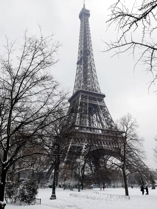 Suasana Menara Eiffel yang diselimuti salju di Paris, Prancis (7/2). Hujan salju yang sangat lebat membuat transportasi umum di paruh utara Prancis dan di Paris tidak dapat beroperasi. (AFP Photo / Thomas Samson)