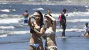 Dua wanita berselfie selama teriknya musim panas di Pantai Shonan di Fujisawa, dekat Tokyo, Selasa, (11/8/2020). (AP / Koji Sasahara)