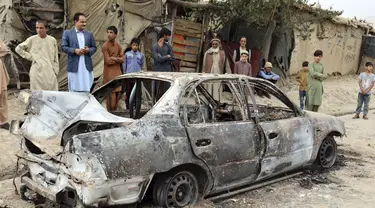 Penduduk setempat melihat kendaraan yang rusak akibat serangan roket di Kabul, Afghanistan, Senin (30/8/2021). Roket menghantam lingkungan dekat bandara internasional Kabul pada hari Senin di tengah penarikan AS yang sedang berlangsung dari Afghanistan. (AP Photo/Khwaja Tawfiq Sediqi)