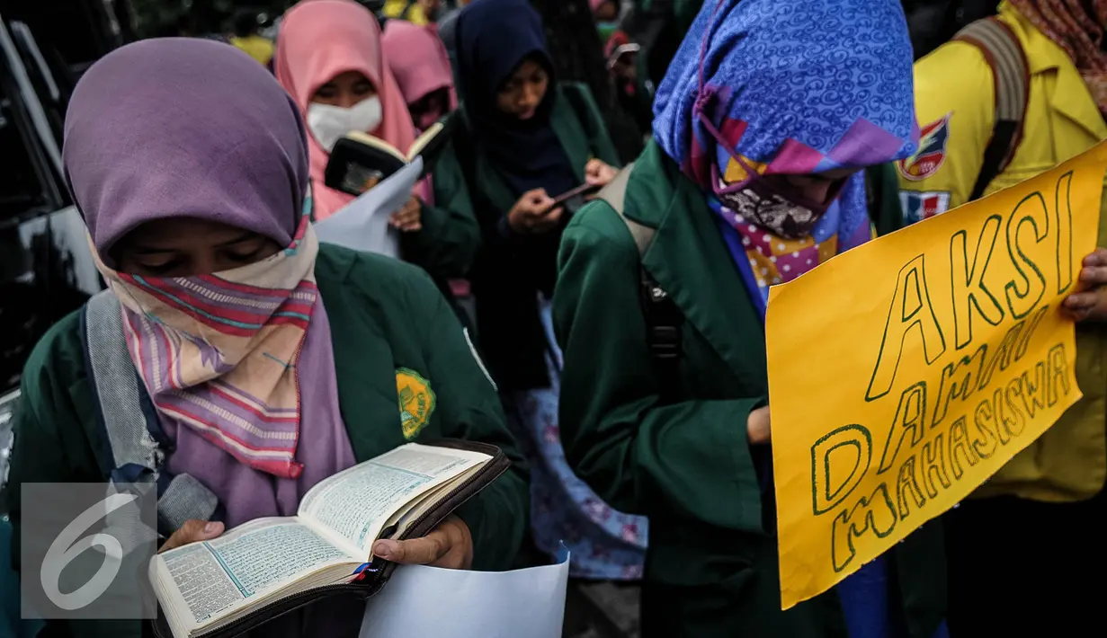 Sejumlah mahasiswi membaca Al-Quran saat melakukan unjuk rasa di depan Balai Kota, Jakarta, Selasa (18/10). Dalam aksinya mereka menyampaikan agar siapa yang melakukan penodaan terhadap ajaran agama harus diproses secara hukum. (Liputan/Faizal Fanani)