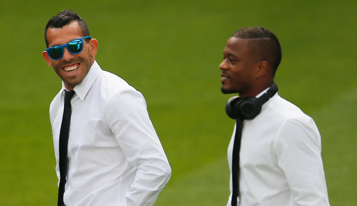 Penyerang Juventus, Carlos Tevez bersama Bek Patrice Evra berbincang jelang persiapan konferensi pers di Stadion Santiago Bernabeu, Spanyol (12/5/2015). Juventus akan menantang Real Madrid di leg kedua semifinal Liga Champions.  (Reuters/Sergio Perez)