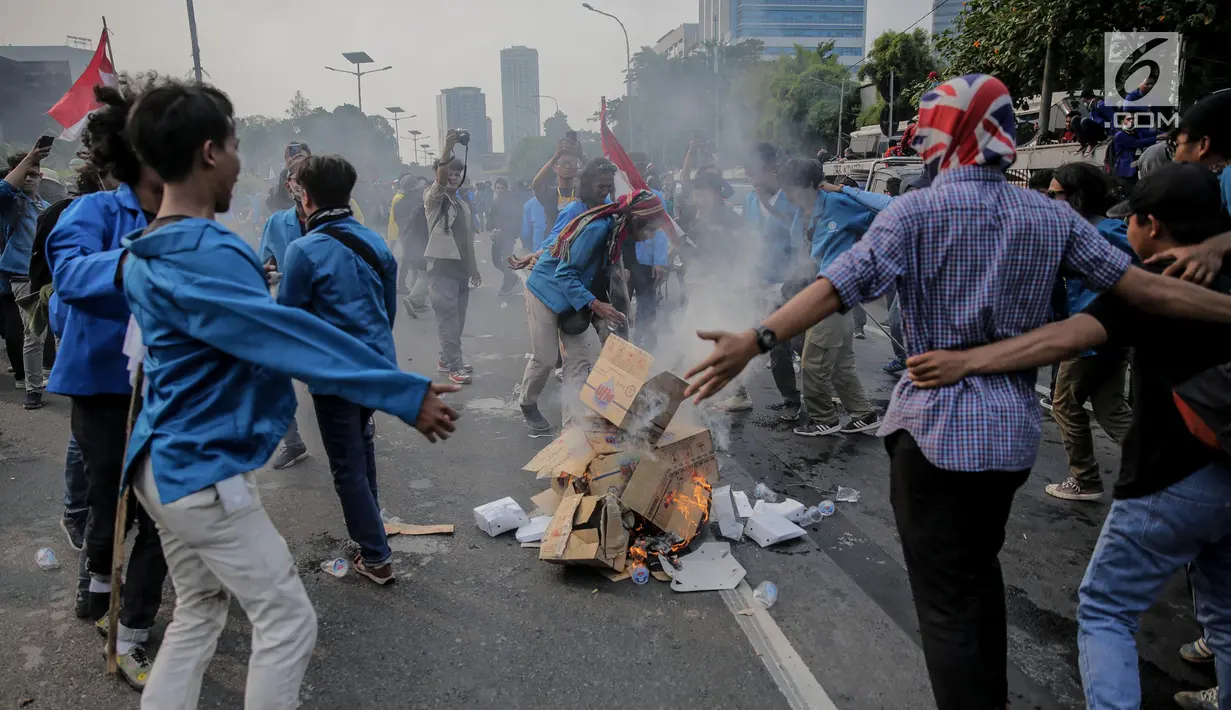 Mahasiswa peserta aksi melakukan pembakaran sejumlah kardus saat menutup tol dalam kota di depan Gedung DPR/ MPR RI, Jakarta, Selasa (24/9/2019). Demonstrasi mahasiswa di depan Gedung DPR ini di antaranya menuntut penolakan atas pengesahan sejumlah RUU kontroversial. (Liputan6.com/Faizal Fanani)
