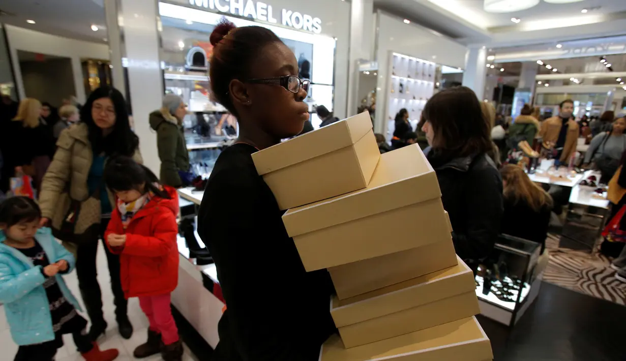 Pekerja membawa sejumlah kotak sepatu selama selama perayaan Black Friday di Macy Herald Square, Manhattan, New York, Kamis (24/11). Black Friday menjadi penanda dimulainya musim berbelanja bagi warga AS menjelang Natal. (REUTERS/Andrew Kelly)