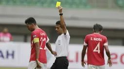 Wasit Thoriq Alkatiri memberikan kartu kuning kepada pemain Semen Padang pada laga Piala Presiden 2019 di Stadion Patriot, Jawa Barat, Minggu (3/3). Thoriq adalah salah satu wasit Indonesia yang berlisensi FIFA. (Bola.com/M Iqbal Ichsan)