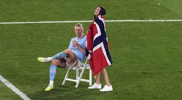 Pemain Manchester City Erling Haaland tersenyum saat duduk di lapangan setelah memenangkan pertandingan sepak bola final Liga Champions antara Manchester City dan Inter Milan di Stadion Olimpiade Ataturk, Istanbul, Turki, Minggu (11/6/2023). (AP Photo/Thanassis Stavrakis)