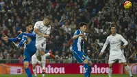Striker Real Madrid, Karim Benzema, menyundul bola ke arah gawang Espanyol pada laga La Liga. Berkat kemenangan ini jarak Madrid dengan pimpinan klasemen, Barcelona, menjadi empat poin. (AFP/Curto De La Torre)