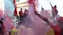 Sejumlah buruh menyalakan bom asap saat menutup aksi Hari Buruh Internasional di Jalan Medan Merdeka Barat, Jakarta, Rabu (5/1/2019). Aksi May Day 2019 di Jakarta ditutup oleh buruh dengan menyalakan kembang api sebagai simbol berjalannya demo dengan damai. (Liputan6.com/Helmi Fithriansyah)