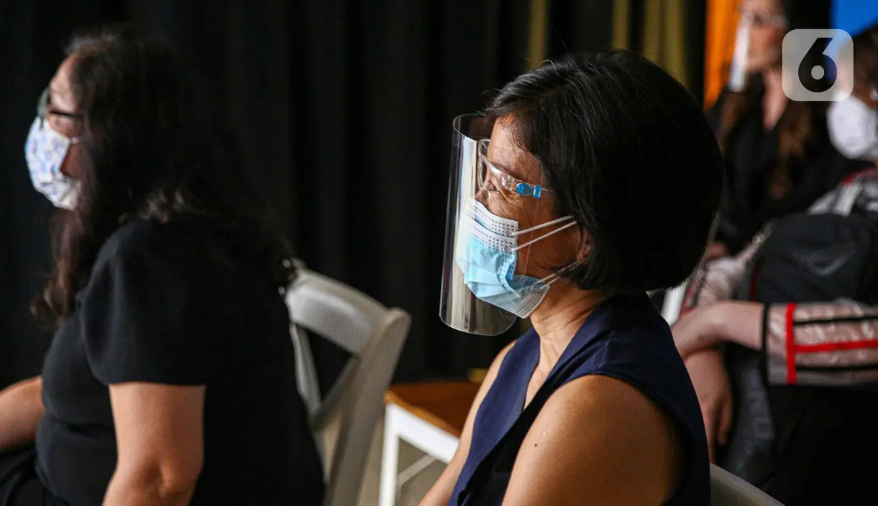 Penonton menggunakan pelindung wajah saat peragaan busana rancangan Audrey Theola bertema Wonder Woman melalui siaran langsung secara streaming di Jakarta, Sabtu (24/10/2020). Fashion show virtual menjadi siasat yang dilakukan pelaku industri mode ketika peragaan busana. (Liputan6.com/Faizal Fanani)