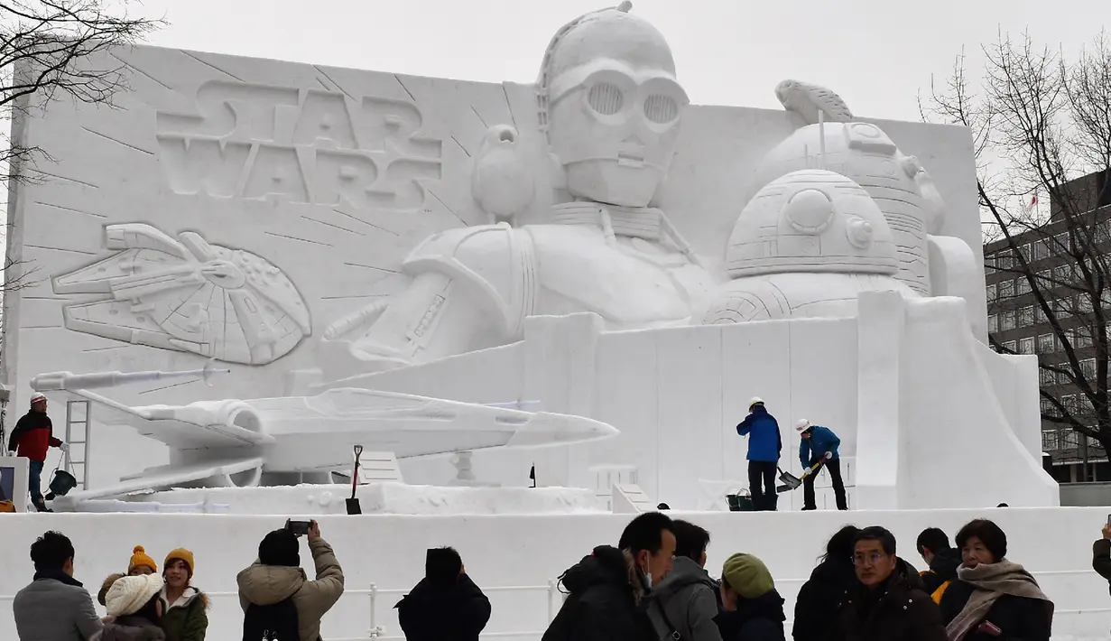 Sejumlah pengunjung melihat patung es Star Wars selama hari pembukaan Festival Salju Sapporo di Sapporo, Jepang (4/2). Festival Salju Sapporo dilangsungkan selama seminggu pada awal bulan Februari. (AFP Photo/Jiji Press)