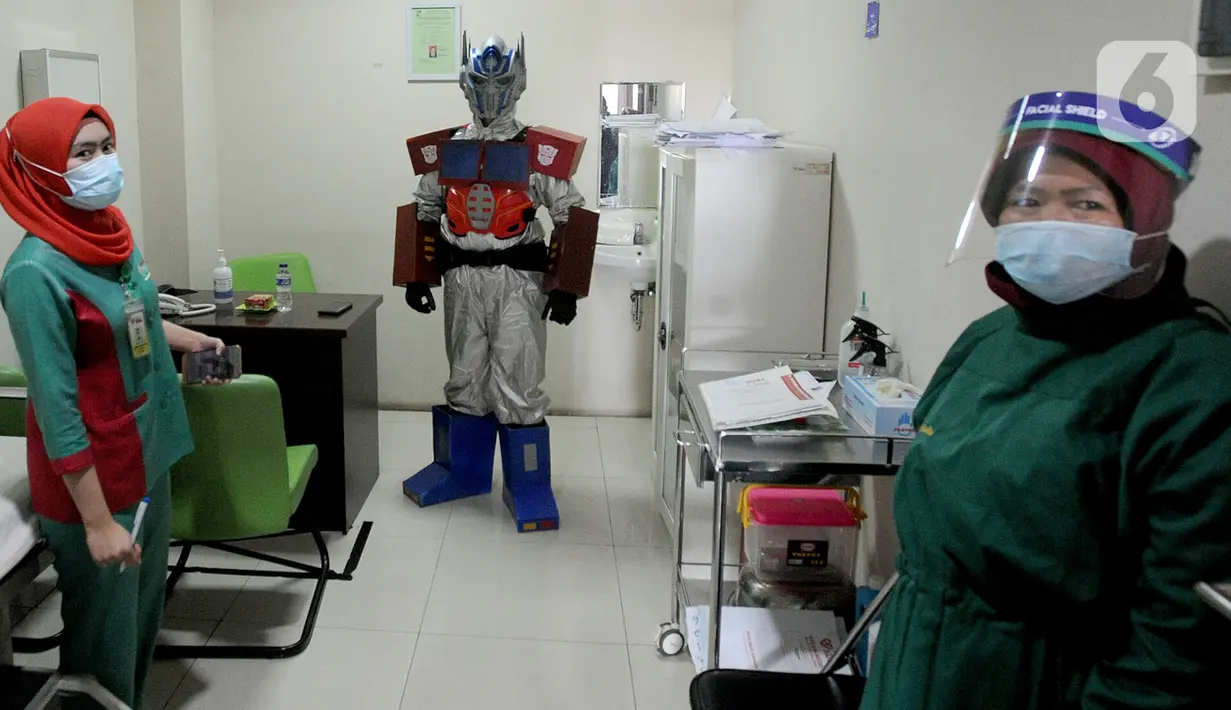 Dokter Rollando Erric Manibuy SpOT mengenakan alat pelindung diri (APD) ala transformer saat berada di RS Vania, Bogor, Jawa Barat, Jumat (22/5/2020). Penggunaan APD unik sejak merebaknya COVID-19 tersebut agar pasien tetap optimis meski sedang dalam pandemi. (merdeka.com/Arie Basuki)