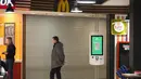 Seorang pria berdiri di sebelah restoran McDonald's yang tertutup untuk pengunjung di sebuah mal di St. Petersburg, Rusia, Selasa (15/3/2022). Gerai makanan siap saji McDonald's resmi menutup 850 gerainya yang beroperasi di Rusia pada 14 Maret 2022. (AP Photo)