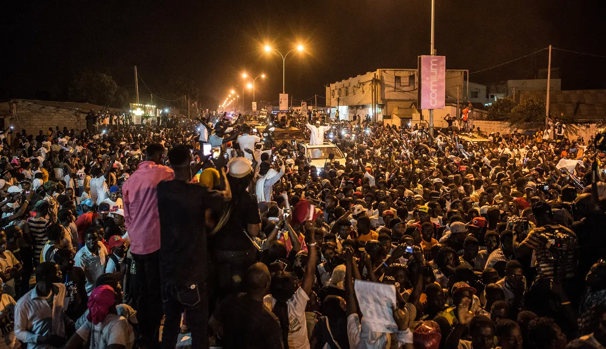 Rakyat menyambut kedatangan Presiden baru Gambia, Adama Barrow yang berada di atas mobil di Westfield, Gambia, Kamis (26/1). Barrow berlindung di Senegal setelah mengalahkan saingannya, Yahya Jammeh, presiden sebelumnya.  (AP Photo/Sylvain Cherkaoui)