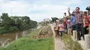 Cagub DKI Basuki Tjahaja Purnama ( Ahok ) menyapa warga dari pinggir sungai saat blusukan ke wilayah Cililitan, Jakarta, Rabu (28/12). Dalam blusukannya tersebut Ahok mencari tahu permasalahan banjir di Cililitan Kecil. (Liputan6.com/Yoppy Renato)