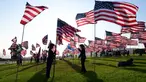 Orang-orang membantu pengibaran bendera AS untuk peringatan 20 tahun serangan 9/11 di Pepperdine University di Malibu, California, Rabu (8/9/2021). Selama 14 tahun, universitas itu memperingati tragedi 11 September 2001 dengan mengibarkan sekitar 3.000 bendera Amerika. (Frederic J. BROWN/AFP)