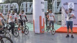 Direktur Utama PT KAI Didiek Hartantyo (kanan) mengibarkan bendera saat melepas peserta sepeda bersama berbagai komunitas Urban SOS Cycling Club di Stasiun BNI City, Jakarta, Sabtu (21/1/2023). Kegiatan olahraga bersepeda yang bertajuk Collaboride digelar dalam rangka mempromosikan Stasiun BNI City sebagai area transportasi publik yang dapat digunakan untuk aktivitas warga. (Liputan6.com/Angga Yuniar)