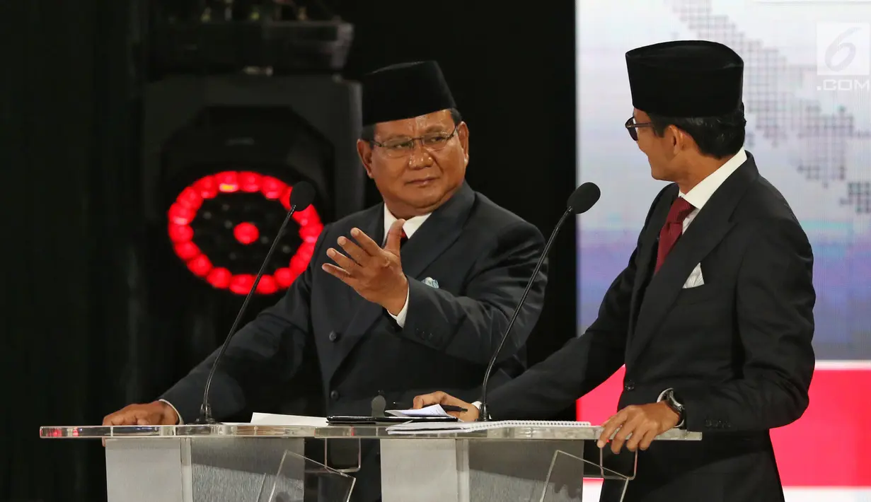 Capres dan Cawapres nomor urut 02 Prabowo Subianto-Sandiaga Uno berbincang saat beradu gagasan selama Debat Pilpres 2019 kelima di Jakarta, Sabtu (13/4). Debat kelima mengambil tema Ekonomi, Kesejahteraan Sosial, Keuangan dan Investasi. (Liputan6.com/Johan Tallo)
