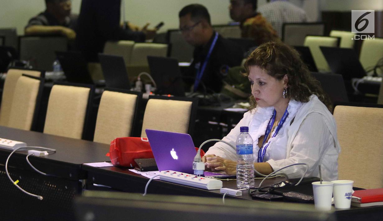 Seorang jurnalis mengetik berita pertemuan tahunan IMF-Bank Dunia di Nusa Dua, Bali, Senin (8/10). Menkominfo Rudiantara memastikan fasilitas internet kencang untuk tamu dan media dalam pertemuan tahunan ini. Liputan6.com/Angga Yuniar)