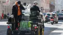 Pengemudi kereta kuda membawa paket makanan di distrik ke-3 di Wina, Austria pada 8 April 2020. Kereta yang disebut Fiaker yang biasanya mengangkut turis berkeliling, kini semenjak pandemi Corona beralih fungsi menjadi pengantar makanan untuk warga lanjut usia di daerah tersebut. (ALEX HALADA/AFP)