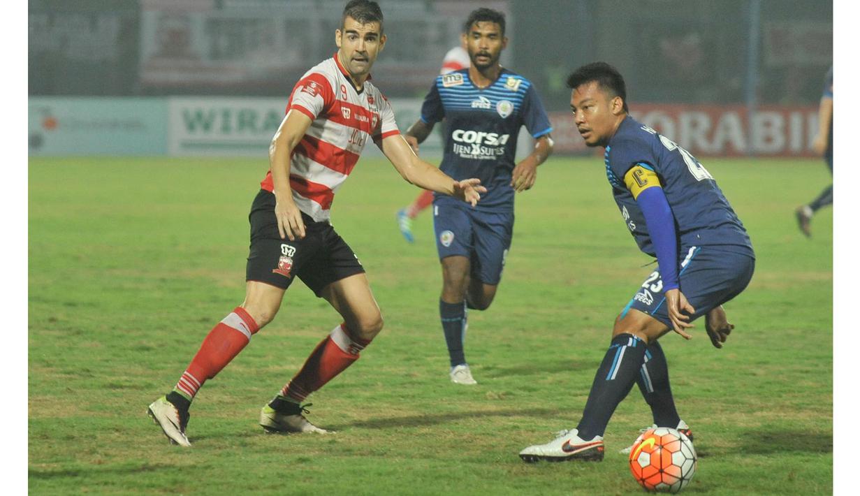 Pemain Arema Cronus, Hamka Hamzah (kanan) mencoba menghadang laju pemain Madura United, Pablo Rodriguez pada laga Torabika Soccer Champions 2016 di Stadion Gelora Bangkalan, Jumat (6/5/2016) WIB. (Bola.com/Fahrizal Arnas)