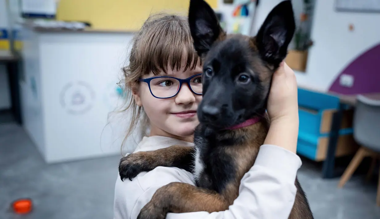 Nastya (9) memeluk seekor anjing bernama Barcelona selama sesi terapi anjing di Kyiv, Ukraina, Kamis, 26 Oktober 2023.